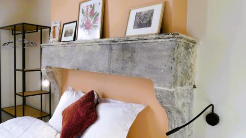 a bedroom with a headboard with pictures on the wall at Sancerre centre, Appartement duplex et ou Chambre indépendante, modulable in Sancerre