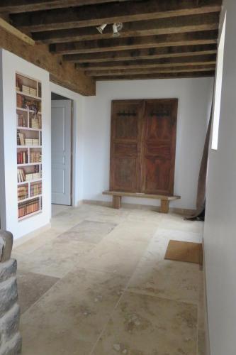 a room with a wooden door and a stone floor at Le Catalpa in Normier