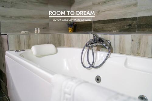 a white bath tub in a bathroom with a sign that reads room to dream at Room to Dream in San Valentino Torio