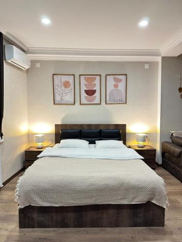 a bedroom with a large bed and two lamps on tables at Woodland Borjomi in Borjomi