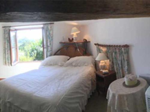 une chambre avec un grand lit et une fenêtre dans l'établissement Les Roses Tremieres, à Saint-Fort-sur-Gironde