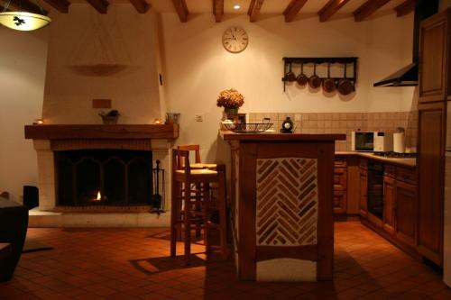 une cuisine avec une cheminée et un comptoir avec une table dans l'établissement SPA et SAUNA privatifs, à Chémery