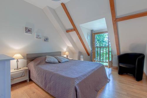a bedroom with a bed and a chair and a window at SPA et SAUNA privatifs in Chémery