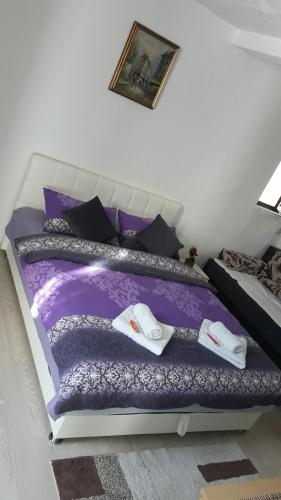 サラエボにあるAPARTMAN AZRAのベッドルーム1室(紫色のベッド1台、タオル付)