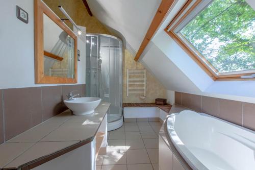 a bathroom with a sink and a tub and a window at SPA et SAUNA privatifs in Chémery