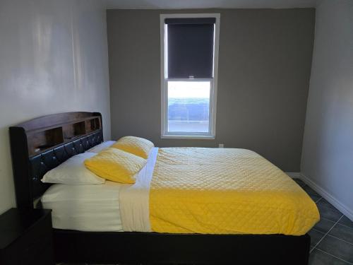 a bedroom with a bed with yellow sheets and a window at The Georges Hidden Gem in Mount Vernon