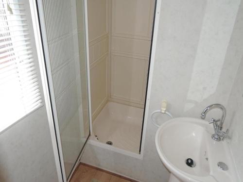 a bathroom with a shower and a toilet and a sink at Mobile Home in Rogowo near Baltic Beach in Mrzeżyno