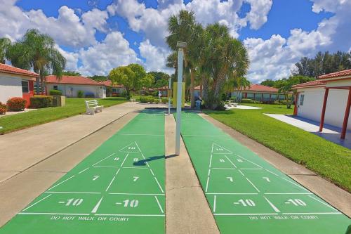 a green tennis court in a residential neighborhood at Siesta Key 2-Bedroom Condo with Pool in Sarasota