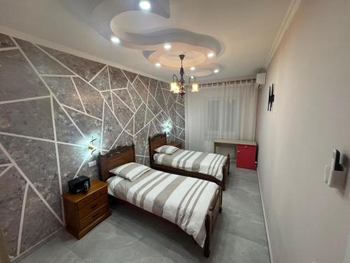 two beds in a room with a stone wall at Leomar Apartament in Gravellona Toce