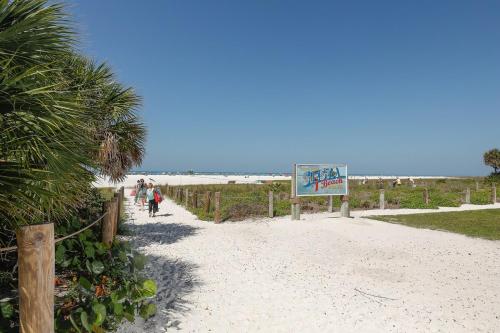 a group of people walking on the beach at 2 bed 2 bath centrally located on Siesta Key in Sarasota