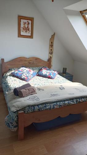 - une chambre avec un lit doté d'un cadre en bois dans l'établissement Maison face à l'île des ebihens, à Saint-Cast-le-Guildo