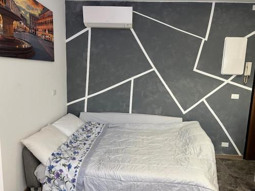 a bed in a bedroom with a wall at Anna Apartment in Padova