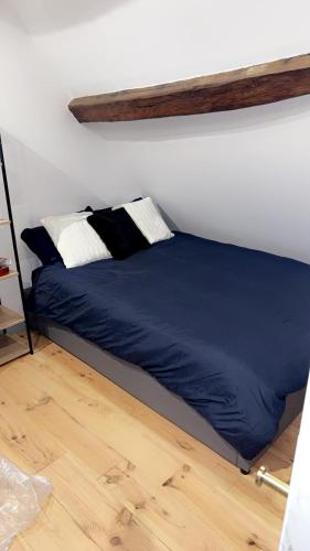 - un lit avec des draps et des oreillers bleus dans l'établissement Le Loft, T2 duplex centre ville historique, à Bourges