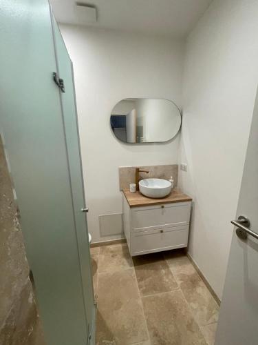 une salle de bain avec un lavabo et un miroir dans l'établissement Spacieux studio - Vieil Antibes, à Antibes