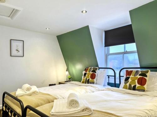 two beds in a room with green walls at The Seaside Snug in Brighton & Hove