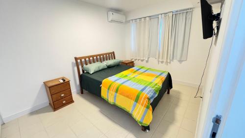 a bedroom with a bed with a colorful blanket at Apart completo RESORT Pé na Areia RECREIO in Rio de Janeiro