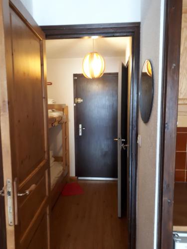 un couloir avec une porte noire et un miroir dans l'établissement T1 Les 2 Alpes Le Kandahar, à Les Deux Alpes