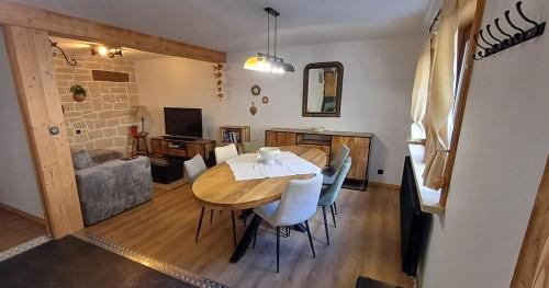 une salle à manger avec une table, des chaises et un canapé dans l'établissement Chez Bernadette, à La Bresse