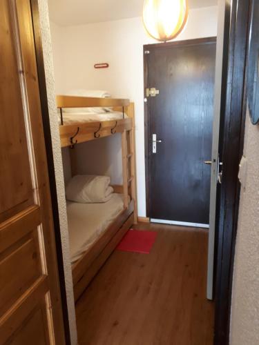 Cette petite chambre comprend des lits superposés et une porte. dans l'établissement T1 Les 2 Alpes Le Kandahar, à Les Deux Alpes