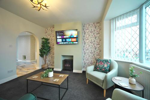 a living room with a fireplace and a tv at Luxury Bungalow, 3 bedrooms, 5 beds, sleeps 8, transport links, parking, Wi-Fi in South Elmsall