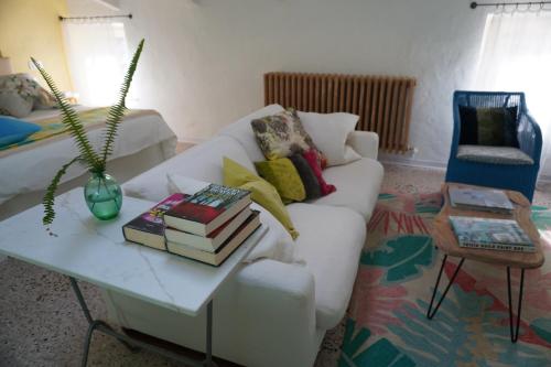 a living room with a white couch and a table with books at Nel mio immaginario in Città della Pieve