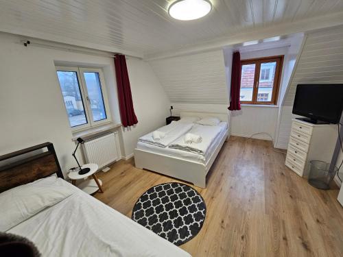 a bedroom with two beds and a flat screen tv at Aparthotel Horn Bahnstrasse in Horn