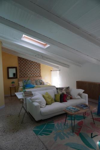 a living room with a white couch and a bed at Nel mio immaginario in Città della Pieve