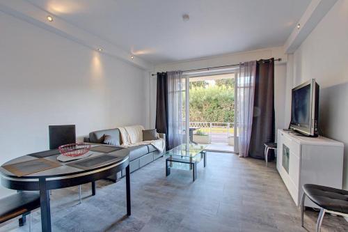 un salon avec un canapé et une table dans l'établissement Appartement T2 climatisé à proximite immediate des plages de juan les Pins, à Juan-les-Pins