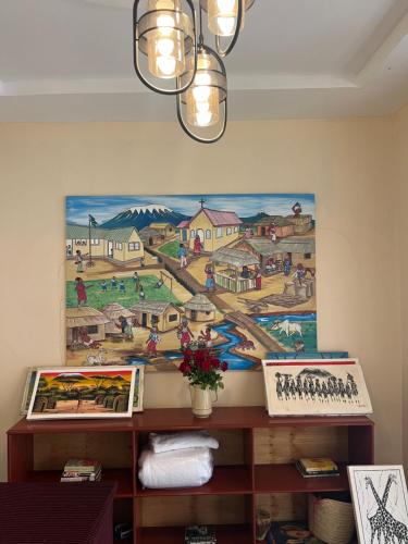 a painting hanging on a wall in a room at Kivuli Inn in Moshi