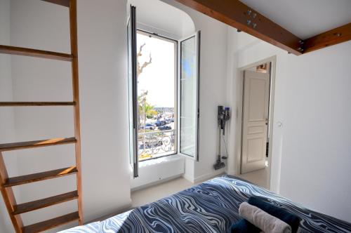 una camera da letto con un letto e una grande finestra di MENTON # MONACO - F1 GP - 4 PERSONS - SEA VIEW - NEW - PARKING - CLIM - PREMIUM - BEACH and SUN a Mentone