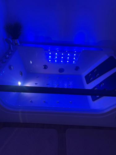 a bed with a blue light in a room at Apartament Gala in Kościerzyna
