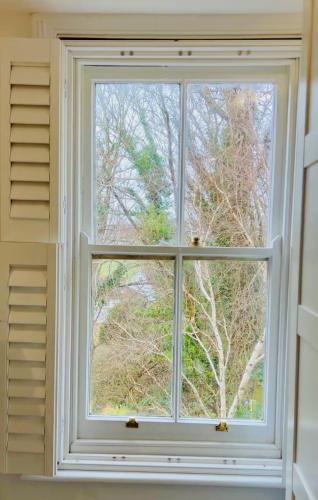 a white window in a room with trees outside at Stylish Brighton Haven, Sleeps 1 to 7, free parking in Brighton & Hove