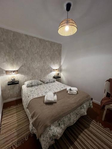 a bedroom with a bed with two towels on it at Juniors Country House in Vila Boim