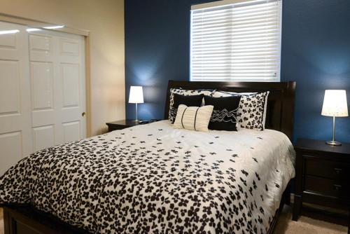 a bedroom with a black and white bed with two lamps at Simply Irresistible in Phoenix