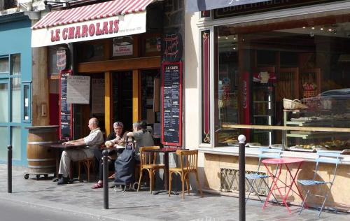 un groupe de personnes assis à l'extérieur d'un restaurant dans l'établissement Charming Aligre Bastille Neighborhood Studio, à Paris