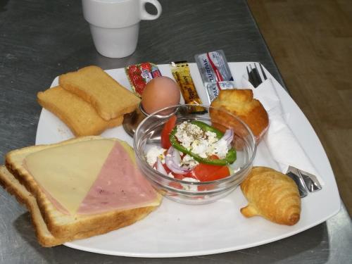 a plate of food with bread and a bowl of food at Akatos Hotel in Agia Marina Nea Kydonias