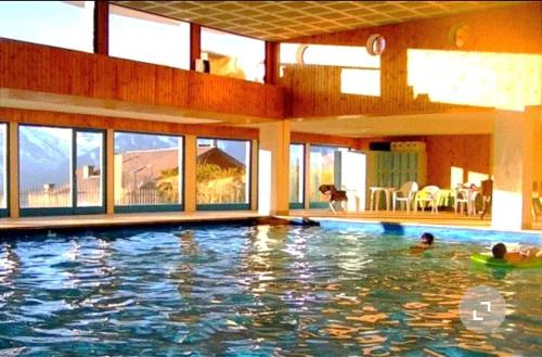two people in a swimming pool in a house at Chalet Alpin, central et parking in Veysonnaz