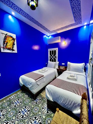 a blue room with two beds in it at RIAD CHENGLI 蓝城里 in Chefchaouene