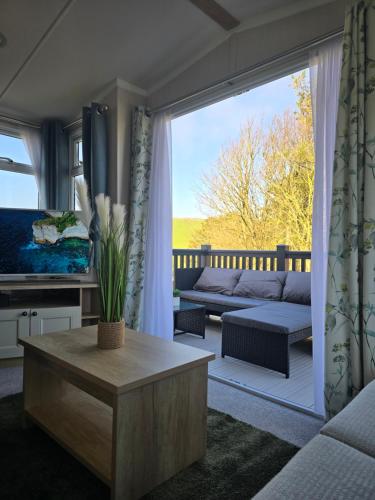 a living room with a couch and a table at Durdle Door family Holiday Home in West Lulworth