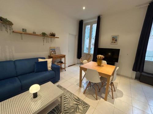 un salon avec un canapé bleu et une table dans l'établissement Nice Renting - GRIMALDI - Best Place Heart of Golden Square - AC - Fully Equipped, à Nice