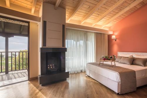 a bedroom with a large bed and a fireplace at Nepheli Hotel in Kastrosikia
