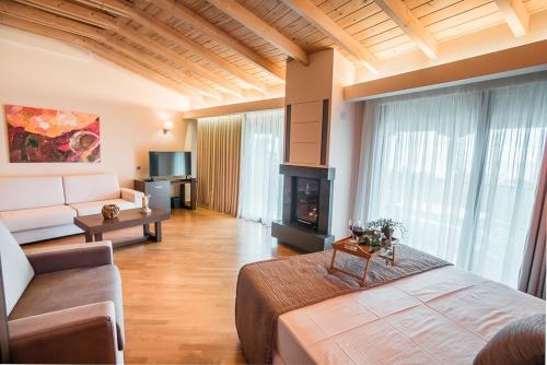 a living room with a bed and a couch at Nepheli Hotel in Kastrosikia