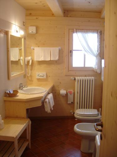 un bagno con lavandino, WC e finestra di Baita De Mario a Valdisotto