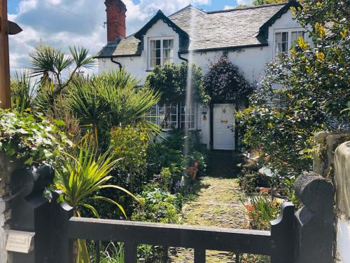 a white house with a gate and a garden at Harbour view cottage, clovelly in Clovelly