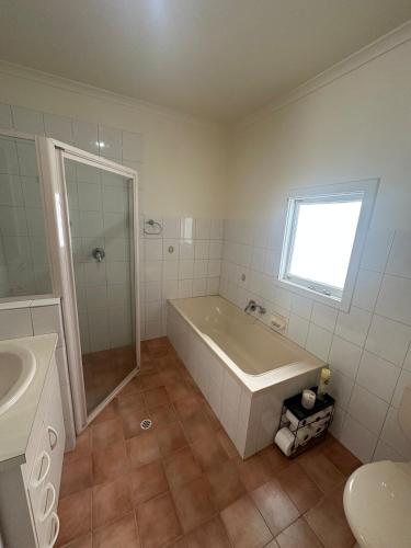 a bathroom with a tub and a shower and a sink at Cottage in Barmera in Barmera
