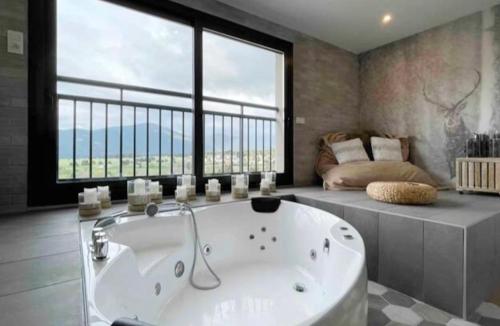 une grande baignoire dans une pièce avec une grande fenêtre dans l'établissement Charmant duplex, 110m2, 7 minutes des pistes, 8 couchages, belle vue sur les montagnes, cheminée, à Formiguères