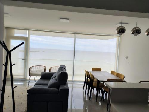 a living room with a couch and a table with chairs at Puerto Madryn Temporarios- Frente al Mar in Puerto Madryn