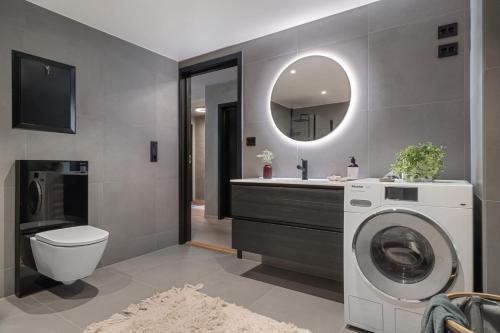 a bathroom with a washing machine and a sink at Modern apartment with a view and parking in Tromsø