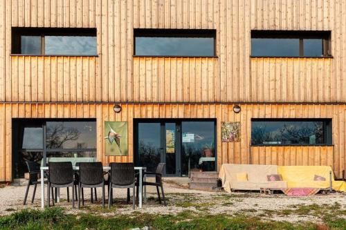 un bâtiment avec une table et des chaises devant lui dans l'établissement Écolodge Entre Nature & Silence Au Coeur du Quercy, à Bétaille