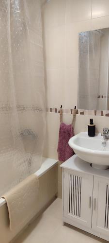 a white bathroom with a sink and a shower at Casa Altaona in Sucina